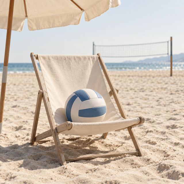 Ein Beachvolleyball macht es sich im Liegestuhl bequem. Das Spielfeld bleibt leer.